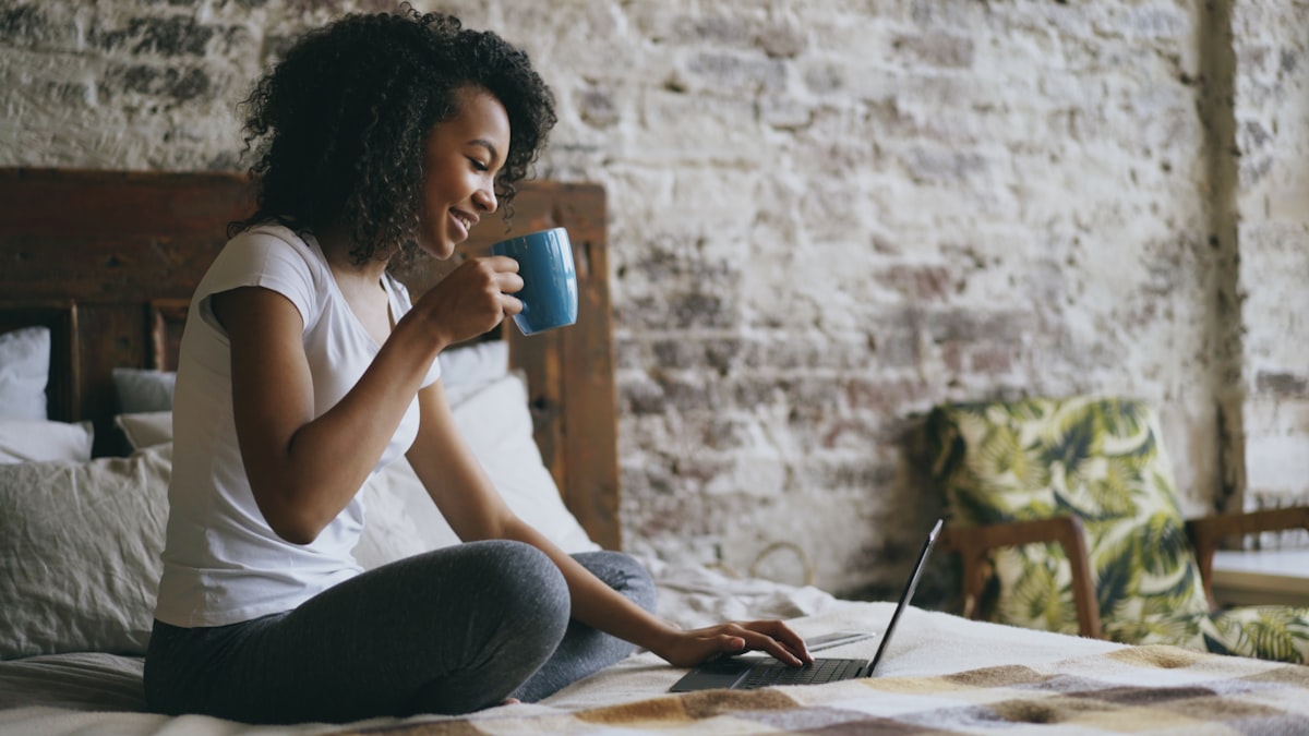 solo founder building her solopreneur stack from home with laptop and coffee