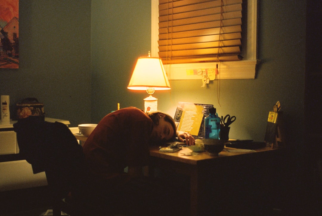 Solo founder asleep at a desk while AI agents work overnight
