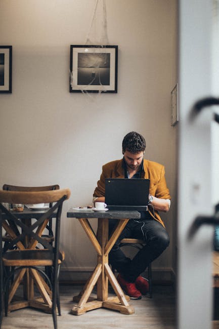 Solo business owner working from cafe with laptop planning next steps