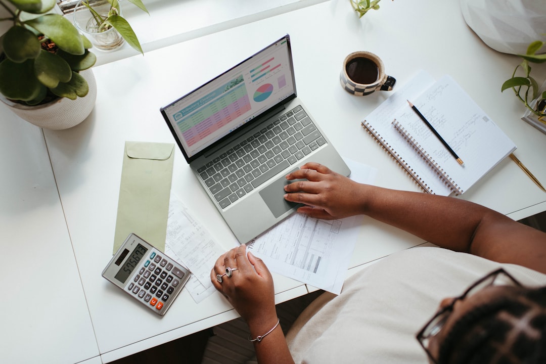 Solopreneur reviewing automated bookkeeping spreadsheet on laptop